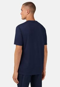 Námořnická modrá bavlněná tričko s kulatým výstřihem a krátkými rukávy, které má jednoduchý design a volný střih.