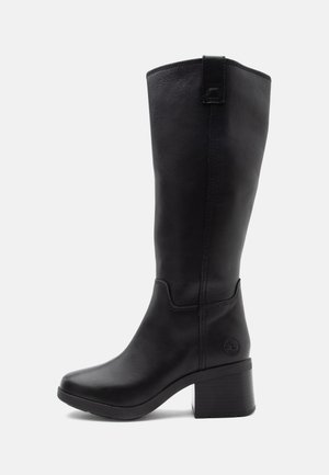 Botte en cuir noire mi-mollet avec talon bloc, bout arrondi, languette de tirage et logo embossé près du talon, vue de profil.