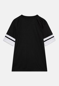 Svart kortärmad skjorta med rund halsringning. Vita ärmar med två svarta ränder. Slät tygkvalitet och lös passform.