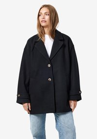 Schwarzer Wollmischung-Übergröße-Mantel mit Reverskragen, zwei Knöpfen und seitlichen Taschen. Mit umgeschlagenen Bündchen und einem lockeren Schnitt.