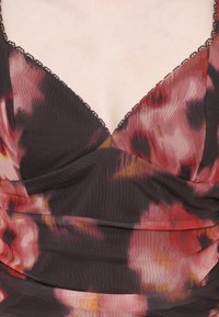 Țesătură închisă la culoare cu un model floral în nuanțe de roșu, roz și galben. Are un decolteu în V și o țesătură delicată din dantelă neagră pe marginea decolteului.