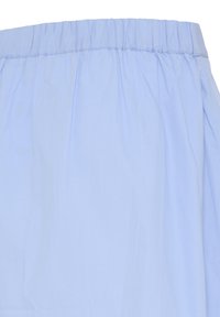 Tissu bleu clair avec taille élastique et détails froncés subtils, probablement une partie d'un vêtement tel qu'un pantalon ou une jupe.