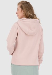 Felpa con cappuccio rosa chiaro realizzata in tessuto morbido, dotata di un cappuccio strutturato e polsini a coste. L'orlo inferiore è dritto e finemente rifinito.