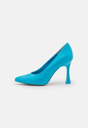 Turquoise gepatenteerd leer hoge hak pumps met een spitse neus en een kenmerkende hoekige hak. Gladde textuur en minimale ontwerpdetails.