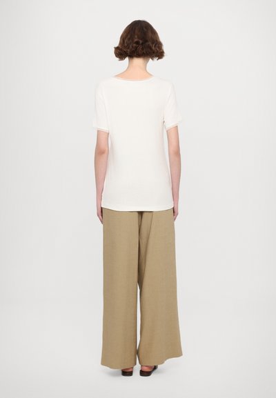 Light beige T-shirt with short sleeves and a round neckline, paired with wide-legged, light brown trousers. Smooth fabric, minimal design.