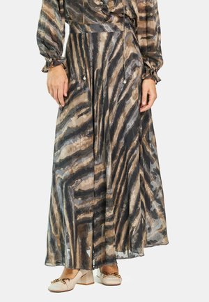 Vestido maxi de tela transparente con un patrón de rayas de cebra en beige, negro y marrón. Mangas largas y cintura con cordón ajustable con acentos de perlas.