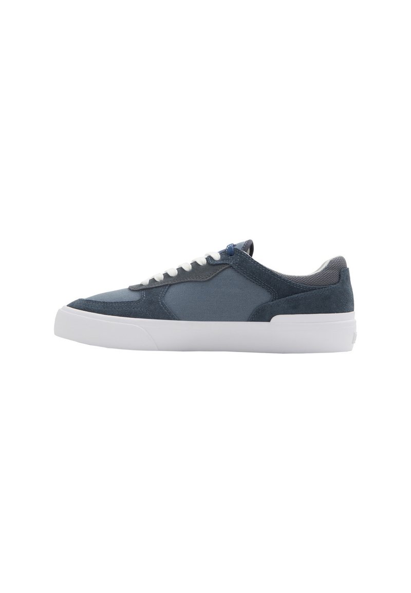 Zapatillas de lona y ante en color marino con cordones blancos, suela de goma y un acabado texturizado. Presentan una silueta suave y acentos contrastantes.