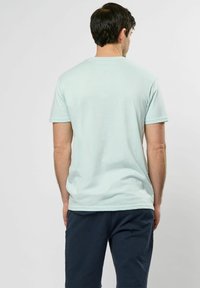 Jasnoniebieska bawełniana koszulka z krótkim rękawem, o standardowym kroju, z okrągłym dekoltem. Minimalistyczny design, bez widocznych wzorów czy logo.