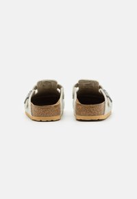 Grijze sleehak sandalen met een kurken zool, rugloze ontwerp en een decoratieve band. Gladde textuur met een natuurlijke afwerking op de zool.