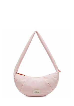 Sac d'épaule rose clair en forme de croissant avec bandoulière rembourrée et tirette de fermeture éclair rouge, avec une petite étiquette blanche avec texte noir.