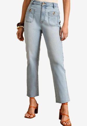 Jeans alta vita di un blu chiaro con due tasche frontali, un taglio dritto e dettagli bronzo sui bottoni. Abbinati a sandali con cinturini marroni.