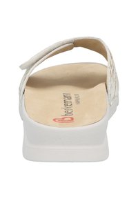 White open-toe sandal with a textured upper, cushioned footbed, and flat rubber sole. Features a Velcro strap for adjustability.