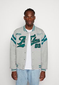 Gray sweatshirt jacket with teal stripes and embroidered "FUBU" logo, featuring snap buttons, ribbed cuffs, and a relaxed fit.