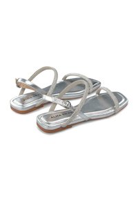 Sandalias planas plateadas con punta cuadrada, que presentan un acabado metálico, tiras delgadas y una hebilla adornada con rhinestones. Suela de goma.