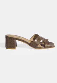 Brown heeled mules in a croc-embossed pattern, featuring a cross-strap design and a moderate block heel. Smooth texture with a square toe.