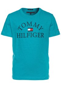 Tyrkysové tričko vyrobené z organické bavlny, s kulatým výstřihem, které má na sobě výrazný černý nápis "TOMMY HILFIGER" a malou vlajkovou značka uprostřed.