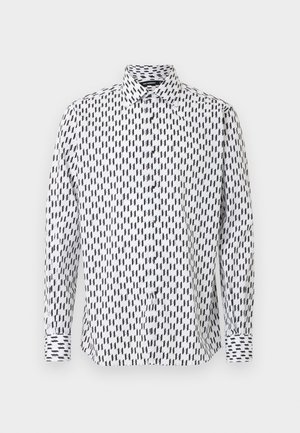 Balta krekla ar garām piedurknēm ar melnu ģeometrisku rakstu, pogu aizdari priekšpusē un klasisku apkakli ar kontrastējošām aprocēm. Mīksta auduma tekstūra.