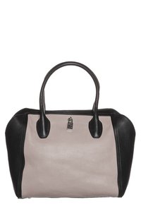 Skórzana torebka w miękkim kremowym kolorze z czarnymi akcentami. Strukturalny kształt, podwójne uchwyty u góry i metalowe detale.