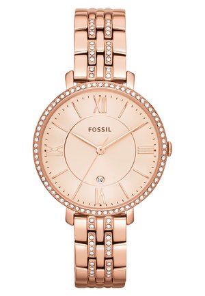 Montre Fossil en or rose avec un cadran rond, des index en chiffres romains, des accents en cristal autour de la lunette, et un bracelet à maillons.