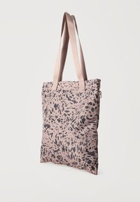 Ανοιχτό ροζ τσάντα ώμου με μαύρα αφηρημένα σημεία, δύο μακριές υφασμάτινες λαβές και πλαϊνό φερμουάρ σε λευκό φόντο.