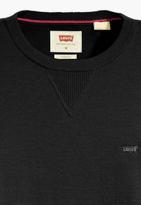 Sweatshirt noir en coton avec col à côtes et encolure en V insérée. Présente un petit logo Levi's brodé en noir sur le côté inférieur.