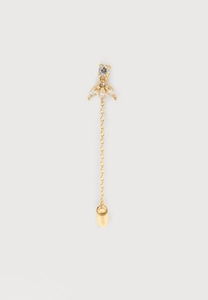 Boucle d'oreille chaîne ton or avec un bouquet floral en cristal clair et un petit pendentif de marque à l'extrémité, présenté sur un fond blanc uni.