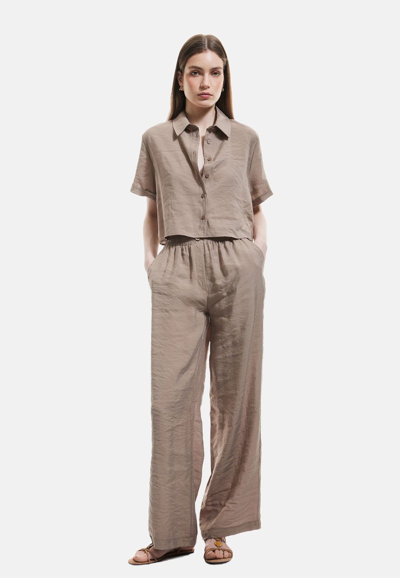 Korte mouwen, geknipte blouse met knoopsluiting en wijde broek in licht taupe stof, met een elastische tailleband en zijzakken.