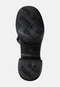 Sole di scarpa in gomma nera con logo "Camper" in rilievo, superficie liscia, forma arrotondata e indicatore di taglia 38.