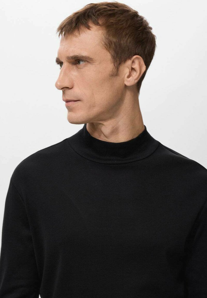 Black, turtleneck sweater made of smooth fabric. Features a fitted design with long sleeves and subtle stitching details.