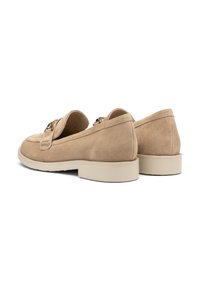 Beige mokasiner av semsket skinn med rund tå, dekorativ stropp og flat gummisåle. Myk tekstur med jevne sømdetaljer på sidene.