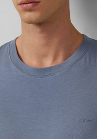 Katoenen t-shirt in lichtblauw met een ronde halslijn. Bevat een subtiel s.Oliver-logo geborduurd aan de linkerkant, zachte textuur.