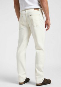 Jeans bianchi a gamba dritta in denim, con design per la tasca posteriore e etichetta in pelle in vita. Tessuto liscio, vestibilità casual.