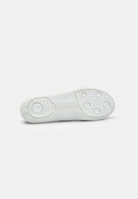 White athletic shoe sole with textured zigzag pattern, circular traction points, and smooth accents. Flat design optimized for grip.