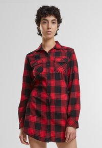 Rochie cămașă din flanel, cu carouri roșii și negre, având închidere cu nasturi în față, guler și două buzunare pe piept. Mâneci lungi cu manșete cu nasturi.
