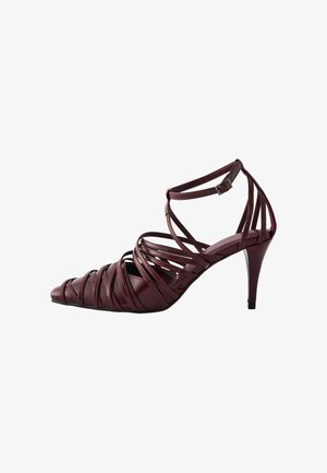 Burgundy high-heeled sandals with a strappy design, pointed toe, and an ankle strap featuring a metal buckle. Smooth leather texture.