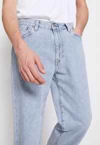 Ljusblå denimjeans med rak passform, med knapp- och dragkedjestängning, fem fickor och subtila sömnadsdetaljer.