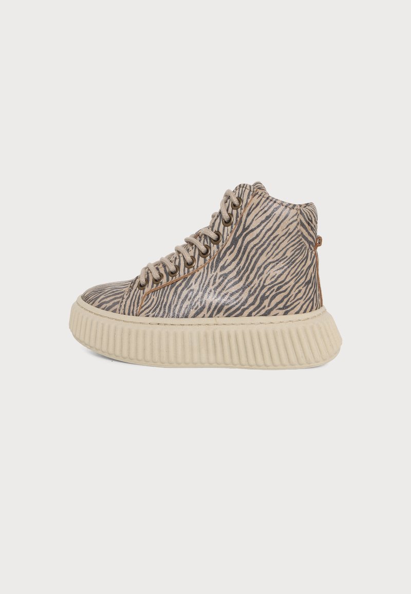Baskets montantes avec rayures zébrées beige et noir, lacets beiges et semelle épaisse côtelée couleur écrue, présentées de profil sur fond blanc.