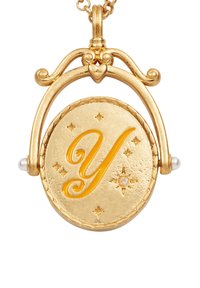 Zlatý náhrdelník s medailónom v oválnom tvare, na ktorom je vyrazené písmeno "Y", doplnený malými perlami a hviezdičkovými akcentmi. Viditeľné detaily štruktúrovaného povrchu.