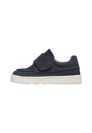 Scarpa per bambino in blu navy con cinturino a strappo, suola bianca e dettaglio di cuciture blu lungo la punta, progettata per essere facile da indossare.