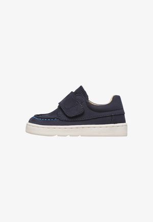 Scarpa per bambino in blu navy con cinturino a strappo, suola bianca e dettaglio di cuciture blu lungo la punta, progettata per essere facile da indossare.
