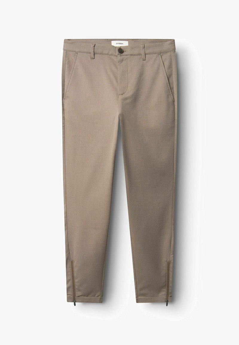 Bēša piegriezuma bikses ar gludu tekstūru, priekšējām kabatām un rāvējslēdzējiem pie potītēm. Etiķete redzama uz jostasvietas.