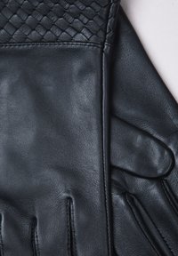 Black leather gloves featuring a woven pattern on the cuff, smooth texture, and stitched detailing along the fingers.
