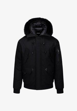 Veste noire isolante avec une capuche bordée de fourrure, plusieurs poches, détail zippé sur le bras, poignets côtelés et silhouette épurée.