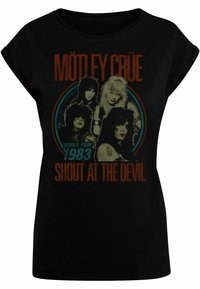 Svart bomull T-skjorte med trykt grafikk av Mötley Crüe med "WORLD TOUR 1983" og "SHOUT AT THE DEVIL" i fargerik tekst.