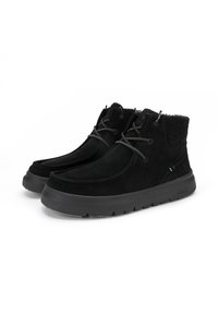 Bottes en cuir suédine noires avec un dessus doux et texturé, fermeture à lacets et semelle en caoutchouc rembourrée. Hauteur cheville avec un dos légèrement surélevé pour le soutien.