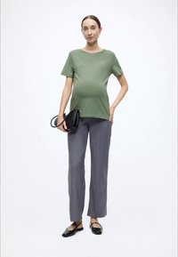 Πουκάμισο μέντας με κοντό μανίκι, γκρι παντελόνι ίσιας γραμμής, μαύρη τσάντα χειρός και μαύρα μπαλαρίνες. Απλός σχεδιασμός με άνετη εφαρμογή.