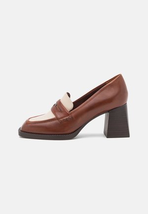 Brown and beige leather block heel loafer with square toe and stitched detailing, shown in side profile on a white background.