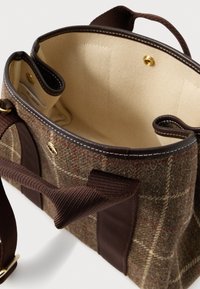 Hnědá kostkovaná vlněná taška s tmavě hnědými popruhy z látky, zlatým zapínáním na patentky, světlou vnitřní podšívkou a vnitřními kapsami pro organizaci.