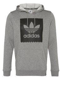 Felpa grigia in cotone con interno in felpa. Presenta un logo nero e una tasca a marsupio sul davanti.