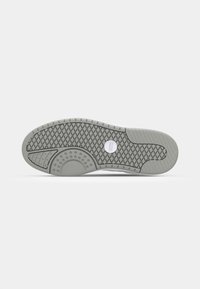Grå sneakersål med en tekstureret, mønstret gummioverflade med en cirkulær detalje og afrundede kanter til trækkraft og støtte.
